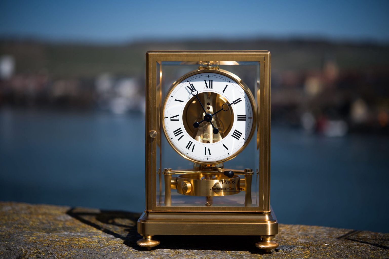 Goldene Atmos-Uhr auf der Mauer am Mainufer in Würzburg
